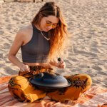 image of woman playing drum at the beach