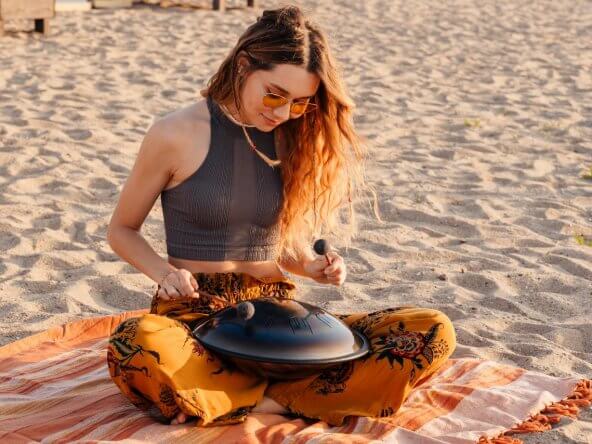 image of woman playing drum at the beach