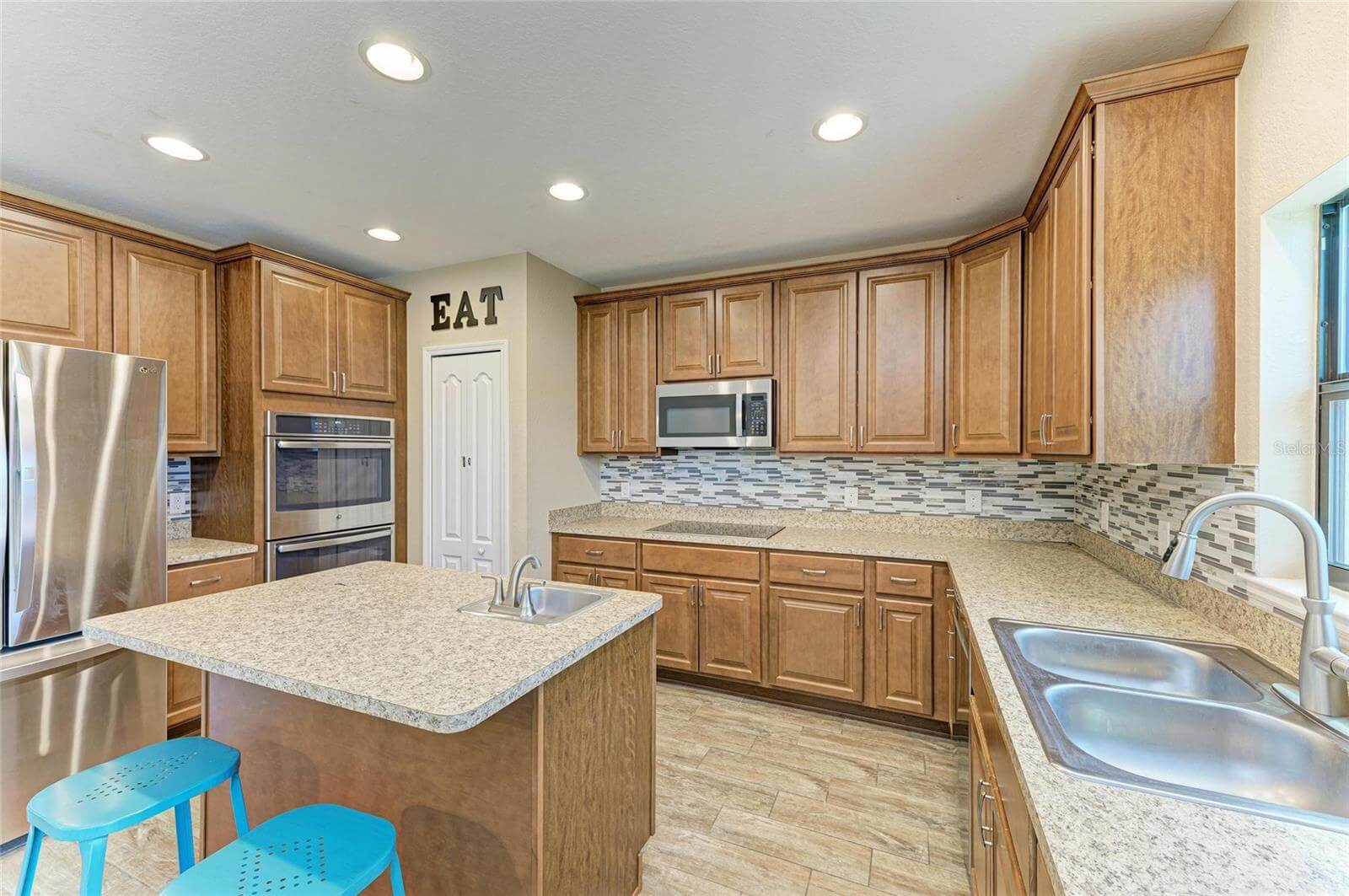 Open kitchen with modern appliances and breakfast bar in 5-bedroom Villa Milano rental, Port Charlotte